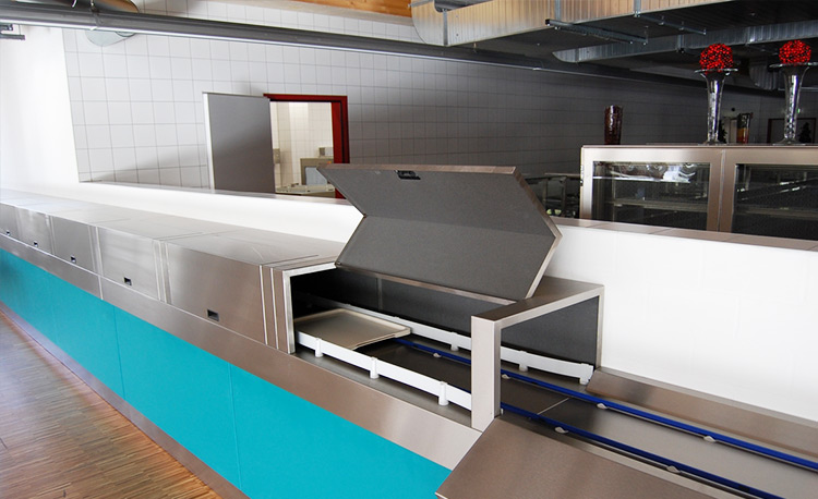 Cover system of a HOBART FLOW Line autoLINE in a modern dishwashing area, featuring an open lid and integrated conveyor for trays, stainless steel construction with hygienic design and optimized workflows.