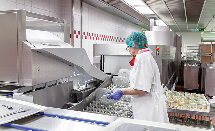 Example of a HOBART FLOW Line autoLINE in a modern dishwashing area, automatic washing system with conveyor for efficient cleaning of plates and glasses, stainless steel design for hygienic and optimized workflows.