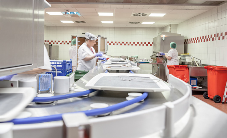 Modern dishwashing area with HOBART FLOW Line autoLINE, automatic washing system featuring conveyor and workstations for efficient cleaning of trays, plates and glasses, stainless steel design for hygienic and optimized workflows.